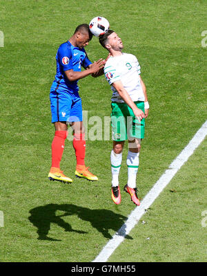 France's Patrice Evra (à gauche) et la République d'Irlande Shane Long (à droite) pendant la série de 16 match au Stade de Lyon, Lyon. Banque D'Images