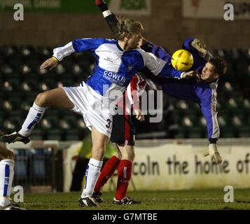 Alan Marriott, gardien de but de Lincoln City, est en chute après un affrontement avec Bristol Rovers Elliott Ward. Banque D'Images