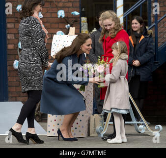 La duchesse de Cambridge reçoit un bouquet de Georgina Willot,12 et Evie Whittaker, sept ans, lors d'une visite à l'usine Emma Bridgewater de Stoke-on-Trent, Staffordshire, pour voir la production d'une tasse que la société a lancée pour soutenir les Children's Hospices d'East Anglia. Banque D'Images