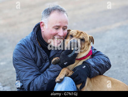 Kai le chien avec son nouveau propriétaire Ian Russell dans un bureau écossais SPCA à Glasgow, après avoir été abandonné à une gare avec une valise pleine de ses affaires. Banque D'Images