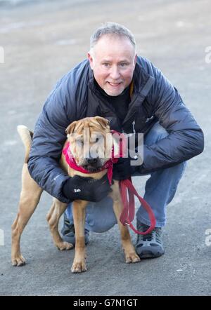 Kai le chien avec son nouveau propriétaire Ian Russell dans un bureau écossais SPCA à Glasgow, après avoir été abandonné à une gare avec une valise pleine de ses affaires. Banque D'Images