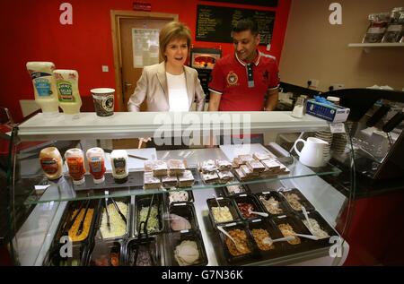 Le chef du SNP et Premier ministre Nicola Sturgeon fait un sandwich dans le bar Quick Bite Sandwich à Glasgow avec la propriétaire Aftab Baig alors qu'elle fait campagne avec des activistes locaux. Banque D'Images