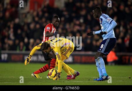 Adrian, gardien de but de West Ham United, lutte pour le ballon avec Sadio Mane (arrière) de Southampton avant d'être envoyé pour le handball à l'extérieur de la boîte lors du match de la Barclays Premier League à St Mary's, Southampton. Banque D'Images