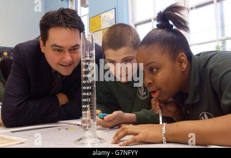 Le ministre des normes scolaires, Stephen Twigg, se joint aux élèves de l'année 11, Lee Mawbey (au centre), 15 ans, et Zuyane Russell, 16 ans, dans une expérience visant à mesurer la vitesse terminale, en utilisant une perle de cellules styro dans l'eau, à l'école secondaire Oaklands. Banque D'Images