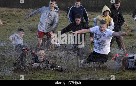 Certains des joueurs tombent pendant le match de football de Shrovetide à Alnwick, dans le Northumberland. Banque D'Images