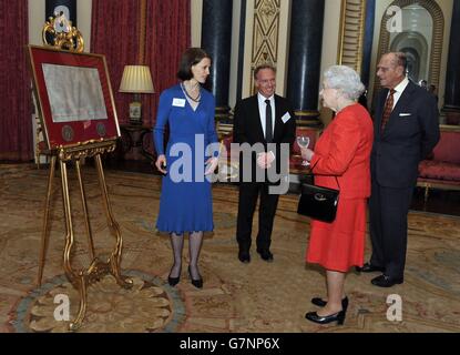 La reine Elizabeth II, accompagnée du duc d'Édimbourg, est présentée une copie de la Magna Carta au Palais de Buckingham, dans le centre de Londres, par la Dre Claire Breay (à gauche) et Clive Izard (au centre) de la British Library, lors d'une réception à l'occasion du 800e anniversaire de la Magna Carta. Banque D'Images