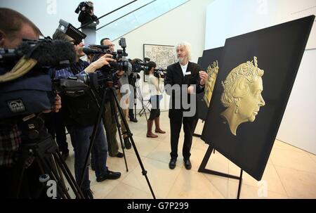 Un assistant à l'événement de la monnaie royale tient une nouvelle pièce de deux livres devant le nouveau portrait de la reine Elizabeth II de l'engraver de la monnaie royale Jody Clark lors d'une cérémonie de dévoilement du dernier portrait de la reine Elizabeth II au National Portrait Gallery de Londres. Banque D'Images