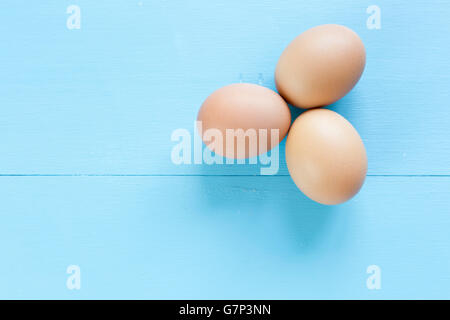 Trois oeufs isolé sur un fond bleu. Banque D'Images