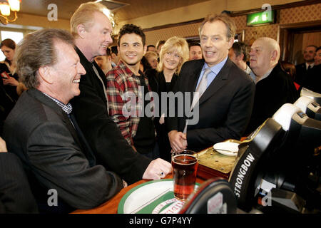 Le Premier ministre britannique Tony Blair aime une pinte d'amers avec des personnages du savon de télévision Coronation Street dans le pub Rovers Return. Banque D'Images