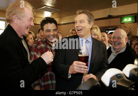 Le Premier ministre britannique Tony Blair aime une pinte d'amers avec des personnages du savon de télévision Coronation Street dans le pub Rovers Return. Banque D'Images