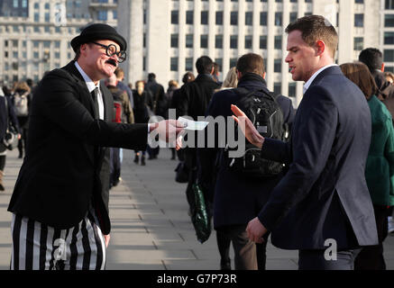 Un acteur, habillé comme un fisc, distribue gratuitement des billets de 5 livres sterling sur le London Bridge pour illustrer une étude de Santander qui montre que les Britanniques distribuent chaque année plus de 57 millions de livres sterling au fisc inutilement en ne profitant pas de l'épargne libre d'impôt. Banque D'Images