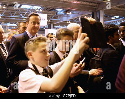 Le Premier ministre David Cameron est photographié avec des élèves lors de sa visite au salon Big Bang UK Young Scientists & Engineers au NEC de Birmingham. Banque D'Images