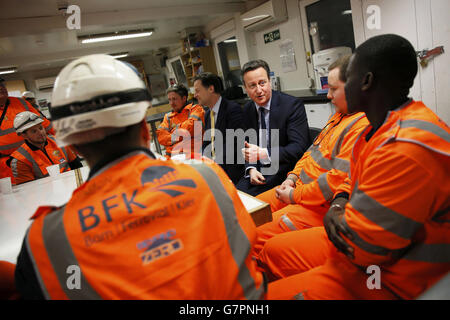 Le Premier ministre David Cameron (troisième à droite) et le vice-premier ministre Nick Clegg parlent à des apprentis de la cantine du site de Caxton Slab de la gare de Crossrail Farringdon, à Londres. Banque D'Images