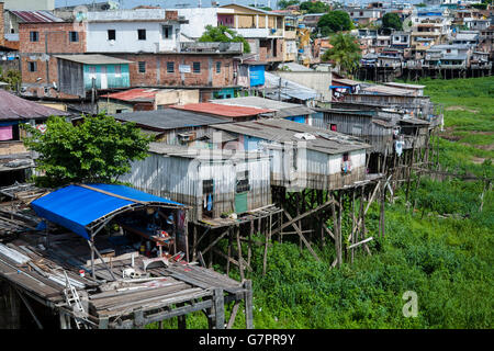 Des maisons sur pilotis dans une favela de la ville de Manaus, domaine où les inondations sont susceptibles de se produire - ordures ménagères et des jetés directement sur rivière, le Brésil. Banque D'Images