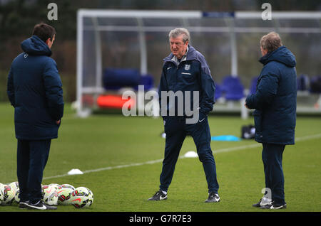 Roy Hodgson, directeur de l'Angleterre, s'entretient avec l'entraîneur Gary Neville (à gauche) et Ray Lewington (à droite) lors d'une séance de formation au centre de formation d'Enfield, à Londres. Banque D'Images