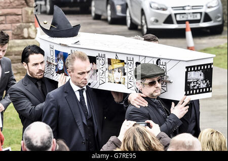 Le visage décoré et le cercueil à chapeau de Steve Strange est sorti de l'église All Saints, Porthcawl, pays de Galles par des membres du Ballet Spandau, y compris Gary Kemp (centre), et Boy George (droite), où les funérailles de la pop star des années 80 ont eu lieu. Banque D'Images