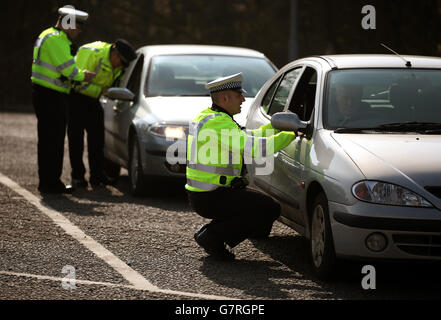 Des policiers vérifient les véhicules lors d'une campagne de police routière à l'opération Westlock à Stirling, tandis que le chef de police écossais Sir Stephen House visite le point d'inspection des véhicules de l'agence de normalisation des véhicules (DVSA) à Craigforth. Banque D'Images