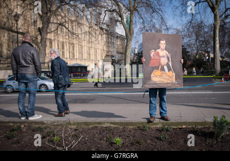 L'artiste satirique Kaya Mar montre son dernier tableau alors que des journalistes, des politiciens et des manifestants se rassemblent sur Abingdon Green devant le Parlement à Londres à la suite de la déclaration budgétaire du chancelier George Osborne. Banque D'Images