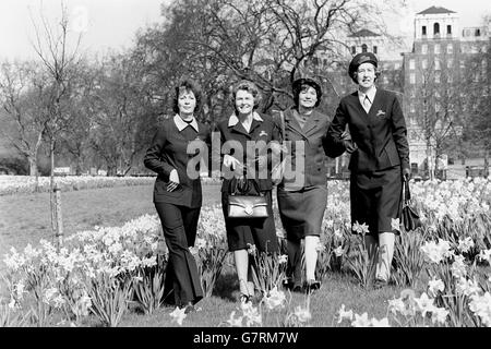 À l'opposé de l'ancien uniforme (deuxième à droite) sont des versions du nouvel uniforme adopté par le Service volontaire royal des femmes (« les femmes en vert ») pour célébrer le 40e anniversaire du WRVS. Le nouvel uniforme, toujours vert, est une série de robes, vestes, jupes, manteaux et pantalons assortis. Parmi les jonquilles de Hyde Park, Londres, se trouvent les membres du WRVS (l-r) Anita Hurwitz, d'Arkley, dans une tenue à pantalon, Connie Ward, de Tonbridge, en robe et en veste, Kaye Barker, de Bickley, dans l'ancien uniforme, et Daphne Maisey, de Wallington, en jupe, chemise et veste. Banque D'Images