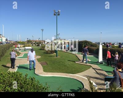 Les gens jouent au golf fou car ils apprécient le temps chaud sur la plage de Hastings, dans l'est du Sussex, car les températures sont sur le parcours pour atteindre le plus chaud de l'année jusqu'à présent, Mais les Britanniques ne devraient pas encore emballer leur veste, car les conditions devraient se refroidir à nouveau vers le week-end. Banque D'Images