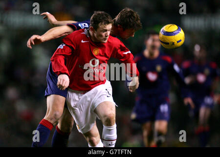 Arjen de Zeeuw de Portsmouth remporte le ballon au-dessus de celui de Manchester United Wayne Rooney Banque D'Images