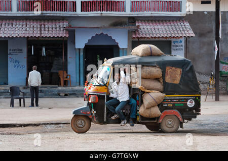 Rickshaw indien avec chauffeur plein de sacs sur la route Banque D'Images