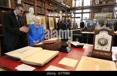 La reine Elizabeth II est présentée des articles de la collection George III relatifs à la science et aux arts, y compris l'horloge Eardley Norton 1765 (à droite) par le bibliothécaire royal Oliver Urquhart Irvine (à gauche) lors du lancement du projet George III lors d'un événement tenu à la Bibliothèque royale, au château de Windsor, Windsor. Banque D'Images