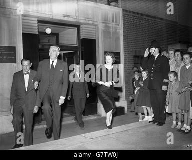 Sir Anthony Eden, Premier ministre, est salué par un policier qui se tient devant un groupe de spectateurs car, accompagné de Lady Eden, il quitte les studios de télévision de la BBC à Lime Grove, Londres, après avoir fait son discours de 14 minutes à la nation sur la crise du canal de Suez. Le premier ministre a été vu par des téléspectateurs de la BBC et de la télévision indépendante, et son discours a également été diffusé à la radio. "Si l'action du colonel Nasser devait réussir", a-t-il dit, "chacun de nous serait à la merci d'un homme pour les approvisionnements sur lesquels nous vivons. Nous ne pourrions jamais accepter cela ». Banque D'Images