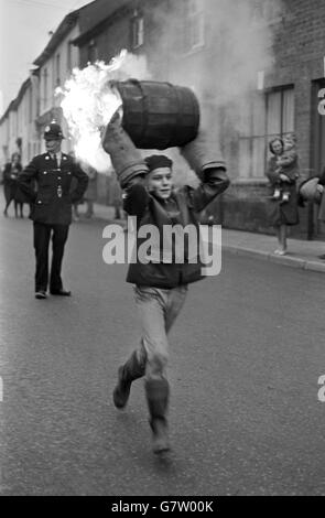 Cérémonie de brûlage du baril de goudron - l'Ottery St Mary's.Un garçon court dans la rue portant un canon en feu pendant l'événement des écoliers. Banque D'Images