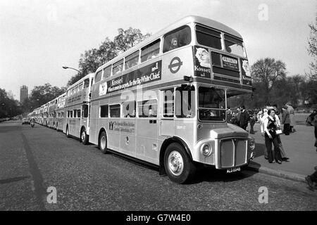 Image montrant les bus du Jubilé d'argent 25 de Londres qui, dans leur nouvelle décoration lumineuse, se sont alignés avant le début du cavalcade de transport de Londres au point de rassemblement de South Carriage Road, Hyde Park, Londres. Les bus argentés, transportant des fêtes spéciales, ont voyagé du parc à travers le centre de Londres et plus à la rive sud en route vers Battersea Park où trois d'entre eux ont participé à la parade de Pâques. Banque D'Images