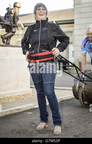 Zara Phillips essaie un baril et un harnais après que le collecteur de fonds de remise en forme Rob Edmond arrive sur la ligne d'arrivée à Tedworth House, après avoir fait rouler un baril de whisky dans le noyau du pays pour recueillir de l'argent pour l'aide pour les héros. 31/03/15 Banque D'Images