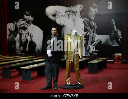 Kevin Kern, directeur de Graceland, à côté du costume d'or d'Elvis Presley, porté par le chanteur sur la couverture de son album « 50,000,000 Elvis fans can't be Wrong », à l'exposition Elvis 02, à l'O2 à Londres. Banque D'Images