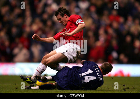 Football - FA Barclays Premiership - Manchester United / Portsmouth - Old Trafford.Matthew Taylor, de Portsmouth, glisse sur Gary Neville, de Manchester United, ce qui entraîne des blessures Banque D'Images