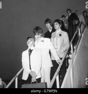 Les Beatles photographiés comme ils sont venus de leur avion à l'arrivée à l'aéroport de Londres de leur tournée américaine tôt aujourd'hui (mercredi).(De gauche à droite) Ringo Starr en veste blanche et pantalon noir, JOHN LENNON en costume blanc et lunettes de soleil, GEORGE HARRISON en costume noir en velours et PAUL McCartney, le seul Bachelor Beatles qui a nié qu'il se mariait.Malgré la petite heure, environ 250 jeunes fans hurlaient sur le balcon du Queen's Building pour donner aux Beatles un accueil bruyant, depuis leur visite au sommet de la série dramatique. Banque D'Images