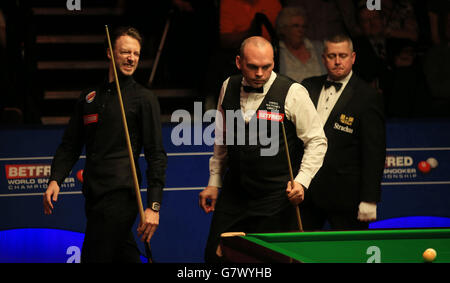 Le Judd Trump (à gauche) d'Angleterre fait des winces après son mauvais coup lors de son match de demi-finale contre Stuart Bingham (au centre) d'Angleterre, le treize jour des Championnats du monde de Betfred au Crucible Theatre, Sheffield. Banque D'Images