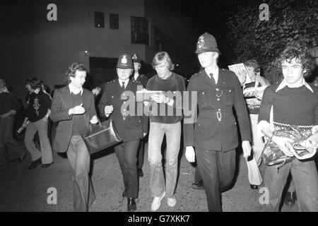 Le champion du monde de course automobile James Hunt est accompagné d'un escorte de police alors qu'il quitte Earls court après avoir visité le salon international de l'automobile. Banque D'Images