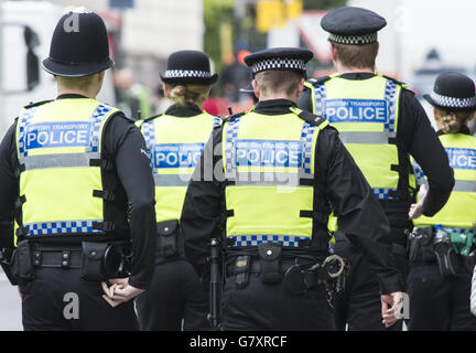 Cinq agents de la police britannique des transports patrouillent dans la rue à Highbury, à Londres. Banque D'Images