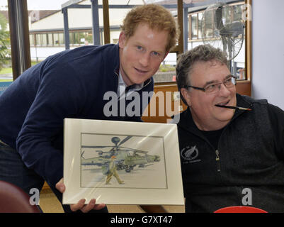 Grant Sharman, 53 ans, qui a cassé le dos en jouant au rugby en 1977 montre au prince Harry une photo qu'il a peinte pour le prince de lui dans l'armée avec son hélicoptère Apache. Ils se sont rencontrés pendant que le Prince visitait une unité de Rehabilitaion spinale/NZ Foundation dans le sud d'Auckland. Banque D'Images