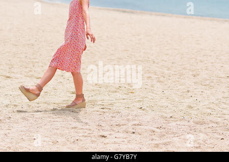 Pieds de la femme sur la plage de sable Banque D'Images