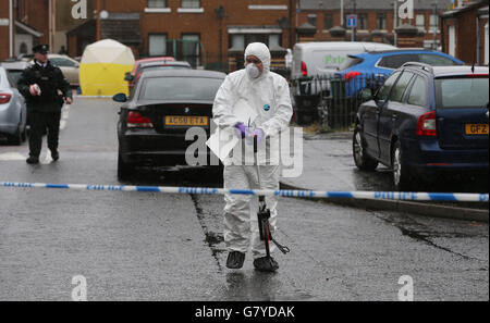 Des policiers et des médecins légistes de Welsh Street, dans la zone des marchés près du centre-ville de Belfast, après la fusillade fatale de Gerard 'Jock' Davison, un ancien commandant de l'IRA. Banque D'Images