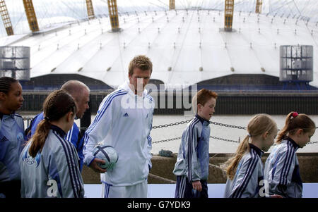 Le footballeur du Real Madrid David Beckham surplombe les enfants qui jouent au football près de la Tamise, pour le lancement de son académie de football afin d'encourager le football populaire. Banque D'Images