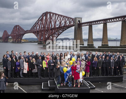 Le Premier ministre écossais Nicola Sturgeon, accompagné de députés et d'enfants nouvellement élus du SNP, devant le pont Forth Rail Bridge dans le sud du Queensferry, le parti marquant sa victoire électorale générale en Écosse. Banque D'Images