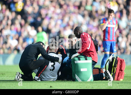 Luke Shaw (3) de Manchester United est traité pour une blessure sur le terrain lors du match de la Barclays Premier League à Selhurst Park, Londres. Banque D'Images