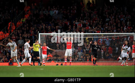 Les joueurs d'Arsenal, y compris Per Mertesacker (au centre), Santi Cazorla (à gauche) et le gardien de but David Ospina, se sont déprimés après que le Bafetimbi Gomis (à droite) de Swansea City ait terminé le premier but du match Banque D'Images