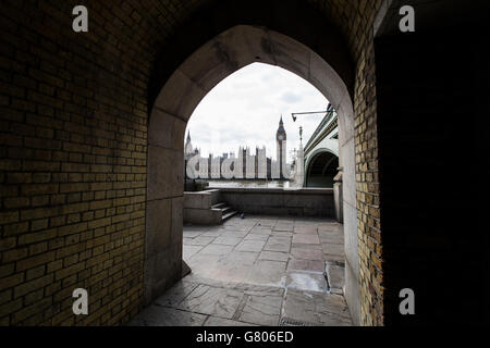 Une vue générale des chambres du Parlement qui regarde de l'autre côté de la Tamise par une arcade en dessous d'une extrémité du pont de Westminster. Banque D'Images