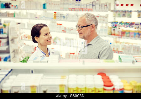 Heureux de parler à un pharmacien senior man at pharmacy Banque D'Images