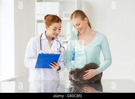 Femme heureuse avec cat et médecin à la clinique vétérinaire Banque D'Images