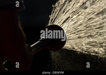 Un steward arrose la cour le douze jour de l'Open de France à Roland Garros le 4 juin 2015 à Paris, France Banque D'Images