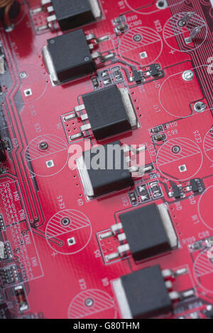 Concept technologique. Carte de circuit imprimé rouge / carte de circuit imprimé rouge montrant une série de composants semi-conducteurs. Câblage à l'intérieur du calculateur, gros plan du circuit, électronique Banque D'Images