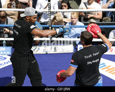 Le boxeur Anthony Joshua MBE s'épargne avec son entraîneur lors d'un exercice de médias à Covent Garden, Londres. Banque D'Images